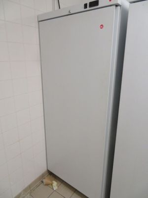 a white refrigerator in a small room with a tile floor