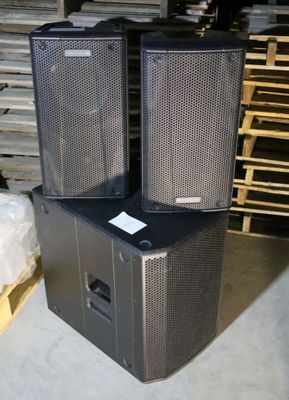 two speakers sitting on top of each other in a warehouse