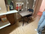 a man standing in a room with a table and a chair