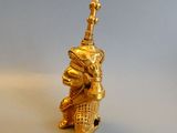 a gold figurine of a man with a hat on his head