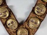 a close up of a gold necklace with skulls on it