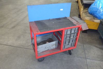 un petit chariot rouge surmonté d'une boîte bleue