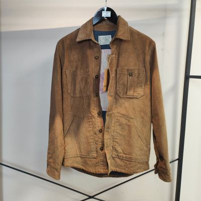 une veste marron suspendue à un portant dans une pièce