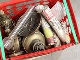 un panier rouge rempli d'objets divers, posé par terre