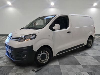 la camionnette blanche est garée sur un sol carrelé en damier