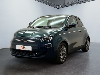 La petite voiture est garée dans une grande pièce aux murs blancs.