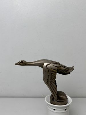 statue of a bird on a white pedestal with a white background