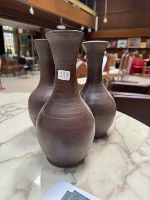 three vases sitting on a marble table in a store