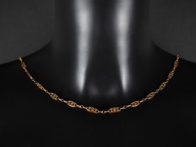 un gros plan sur le torse d'un mannequin portant un collier à chaîne en or