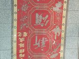 a red banner with chinese writing on it hanging on a wall