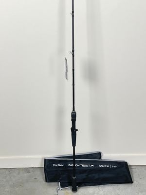 a close up of a black umbrella on a stand in front of a white wall