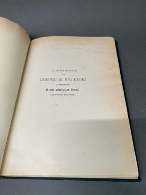 un livre ouvert posé sur une table à côté d'une table noire