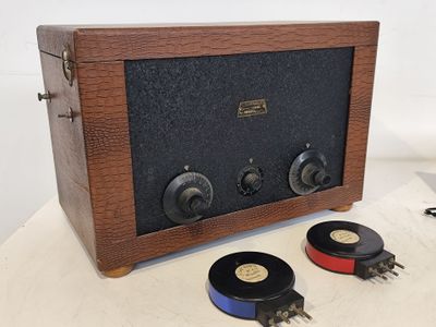une vieille radio posée sur une table à côté d'une paire d'enceintes