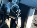 un tableau de bord de voiture sur lequel sont accrochés une clé de voiture et un porte-clés