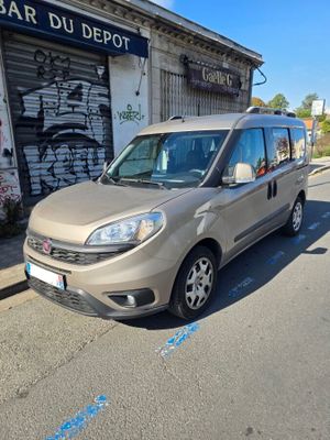 La camionnette est garée sur le bord de la rue, devant un immeuble.