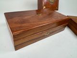 a small wooden box with a lid on a white surface