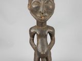 an old wooden statue of a man with his hands on his hips