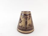 a brown vase that has a design on it