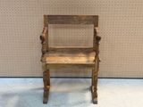 a small wooden chair that is on display in front of a wall