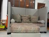 a couch and ottoman in a room with a window