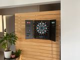 une photo d'un salon avec une télévision et des fléchettes accrochées au mur
