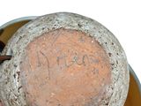 someone is holding a clay pot with writing on the inside of it