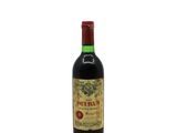 a bottle of red wine sitting on top of a white table