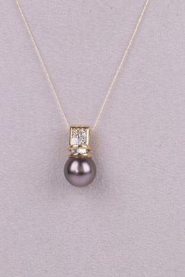 un pendentif composé d'une perle noire et de diamants, monté sur une chaîne en or