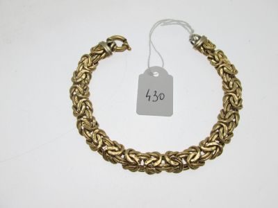 gros plan d'un bracelet en or portant une étiquette de prix