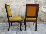 two chairs sitting next to each other on a cobblestone floor
