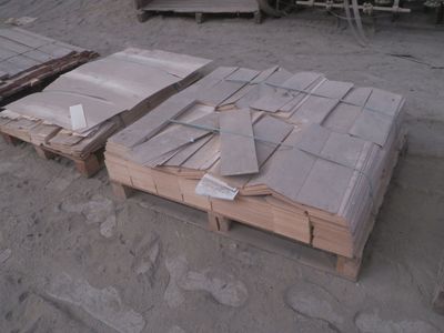 une pile de cartons posée par terre à côté d'une palette