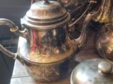 many silver teapots sitting on a table next to each other