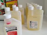several bottles of liquid sitting on top of a counter next to a bag of flour