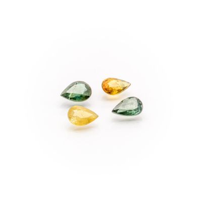 a group of three green and yellow gems on a white background