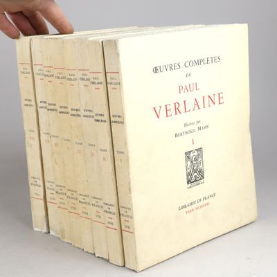 une personne tenant un livre devant une pile de livres
