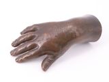 bronze statue of a hand on a white surface with a white background