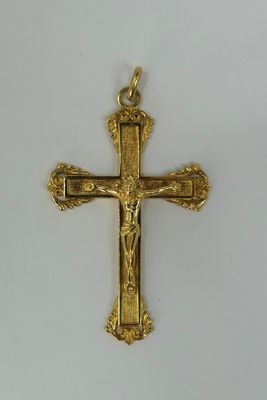 a close up of a gold cross on a white surface