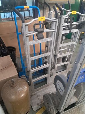 un diable avec une échelle à côté d'une pile de cartons