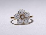 une bague en or surmontée d'une fleur blanche