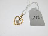 un pendentif en forme de cœur en or auquel est suspendue une perle