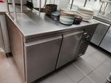 plan de travail en acier inoxydable dans une cuisine commerciale avec des casseroles et des poêles dessus