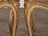 pair of antique wooden chairs on tiled floor in a room