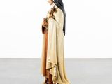 the statue of a woman in a long dress is holding a bag