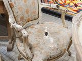 a chair and a table in a room with a painting on the wall