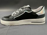 black and silver sneakers with a white sole on a grey surface