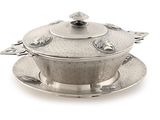 a silver plate with a lid and a saucer on it