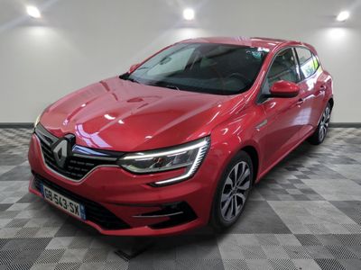une voiture rouge garée dans un garage au sol en damier