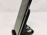a close up of a cell phone on a stand on a white surface