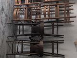 a wall with a bunch of wooden chairs on it