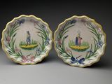 deux assiettes sur lesquelles figurent un homme et une femme dans un bateau